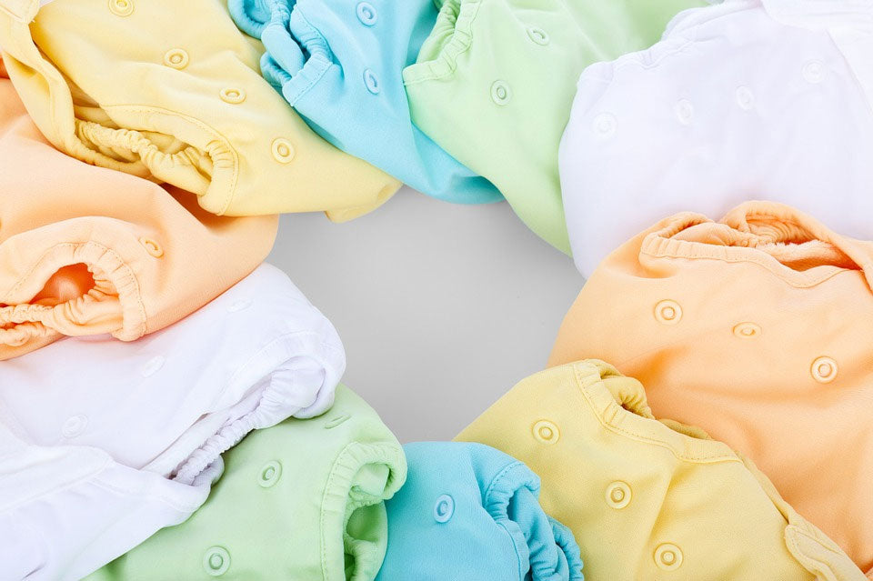 A circle of colorful baby onesies