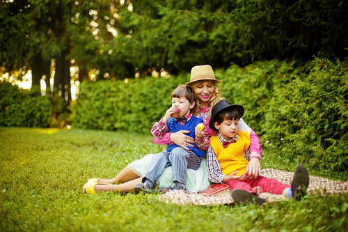 Mom sits on picnic blanket with her two sons