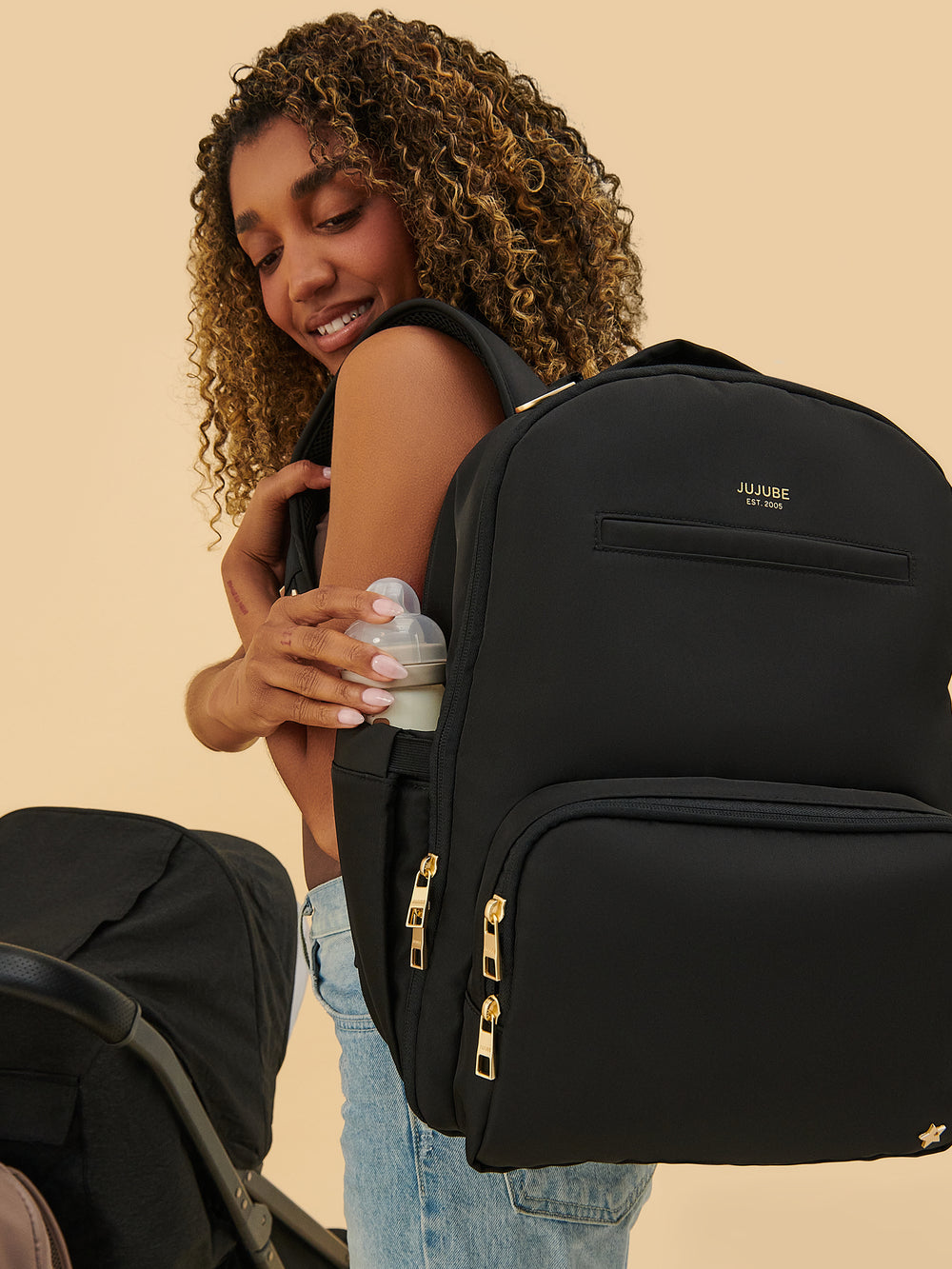 Parent wearing the JuJuBe Classic Diaper Backpack in Black
