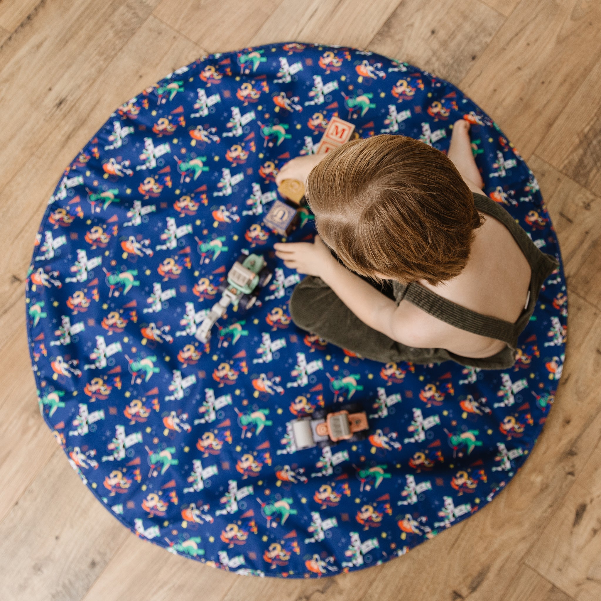  Featuring Woody, Buzz, and all their friends from Toy Story and Disney Pixar's Dr. B.F.F on a dark navy blue background, Toddler Play in Action Lifestyle Shot (Lightweight-Compact-Machine Washable-Play Mat).