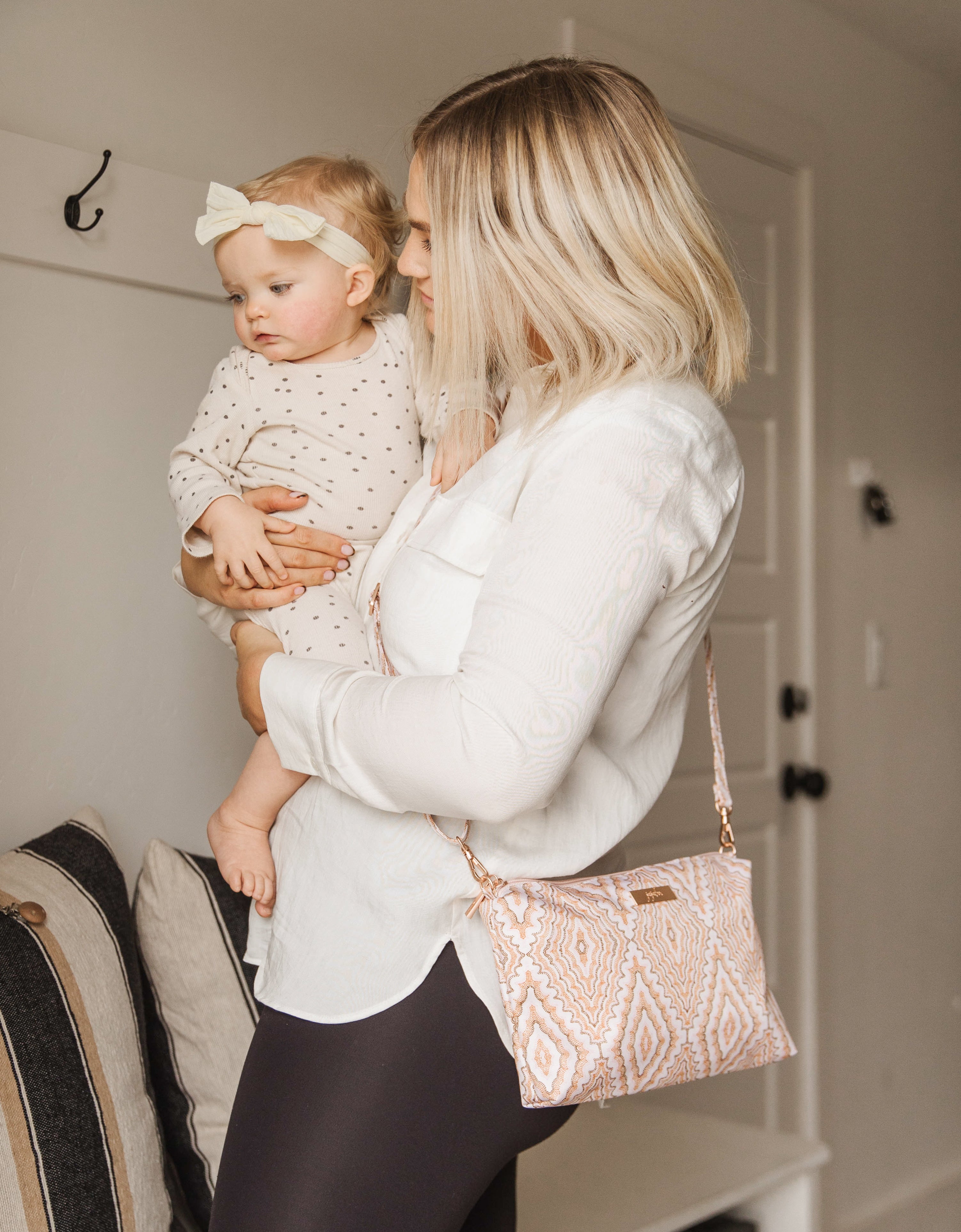 Pink, Orange and Brown Dotted Diamond Pattern Be Quick Worn as a crossbody bag by a woman carrying a baby.