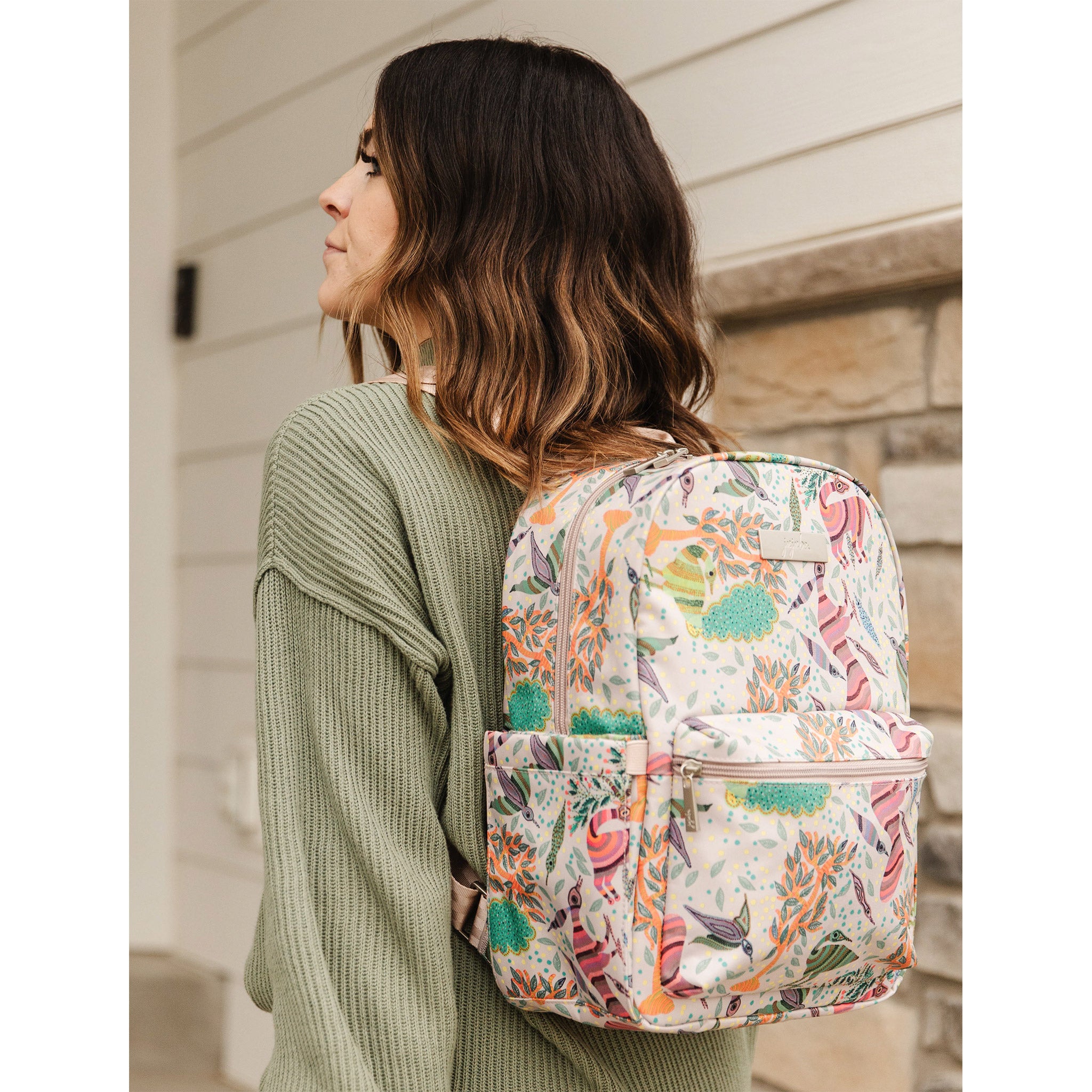 Multicolor Animals, Birds and Trees on a Taupe Background Midi Backpack worn by a Woman.
